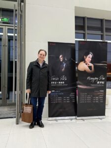 Enrico Elisi stands by concert signage