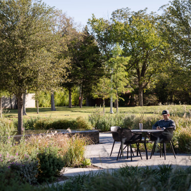 student sitting outside in the common area in front of the FAB