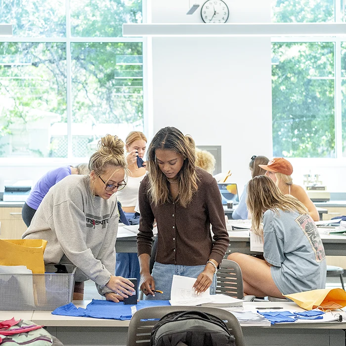 Students review fabric swatches and colors in the Fashion Merchandising lab