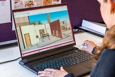 student working on design file on laptop computer