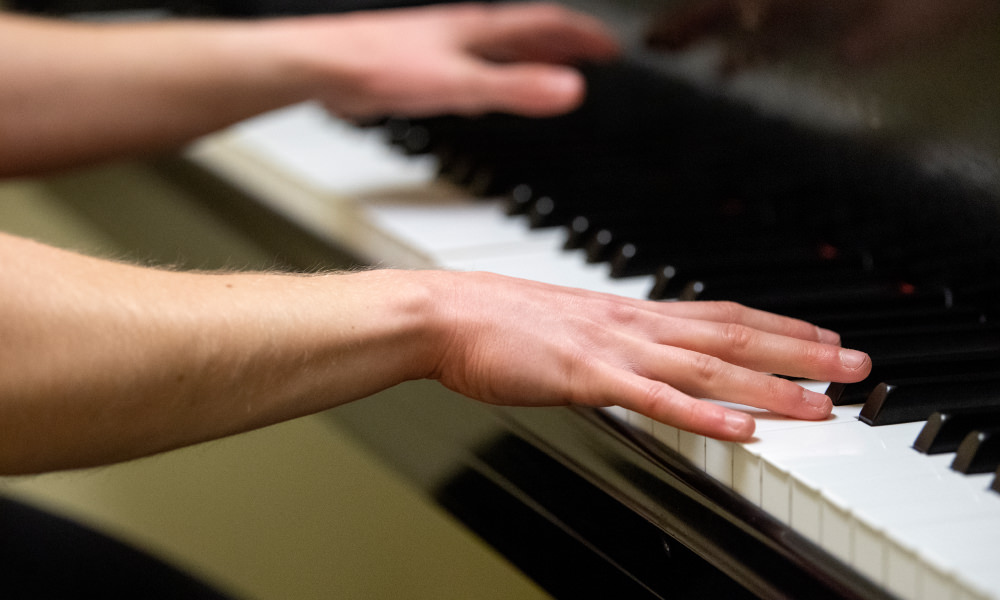 hands playing a piano