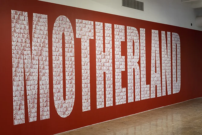 MOTHERLAND in white letters on a red wall